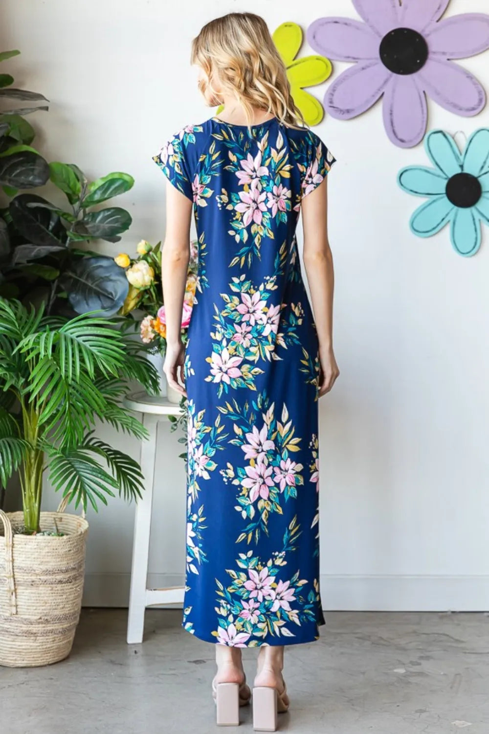 Heimish full size floral short sleeve slit dress with a fitted bodice and flowy skirt, showcasing vibrant floral pattern and elegant design.