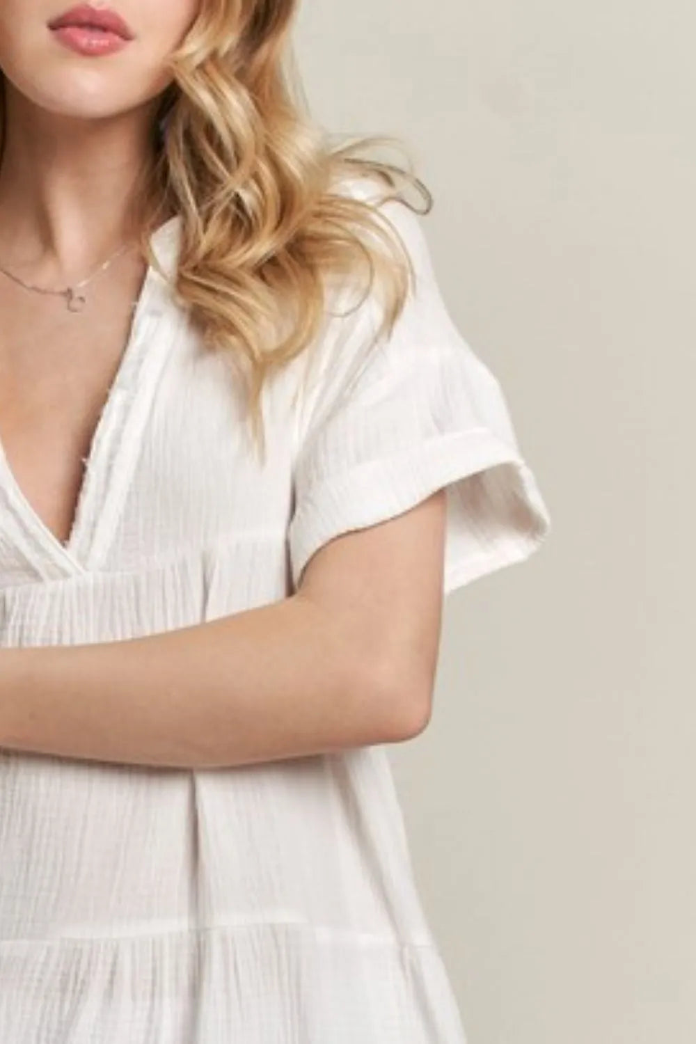 Ivory ADORA tiered notched short sleeve dress by Trendsi, showing its flowy fabric, notched neckline, and tiered design.
