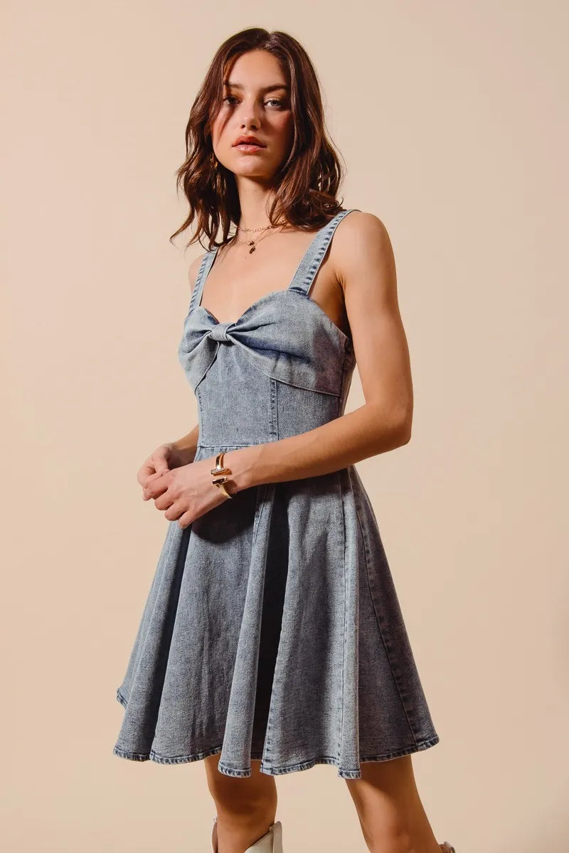 Mineral washed bow ribbon denim flare dress from SO ME by Trendsi, featuring a fitted bodice, bow detail, and flared skirt.