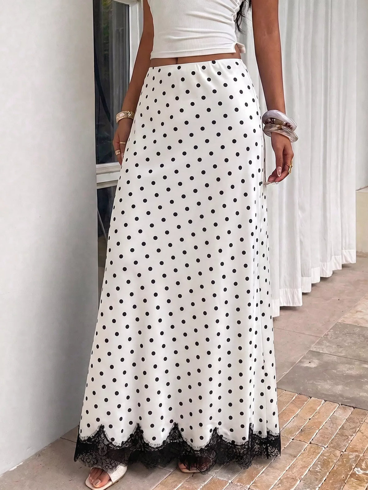 Lace hem polka dot high-waisted maxi skirt from Trendsi, flowing fabric with a fitted waistband and elegant hem detail.