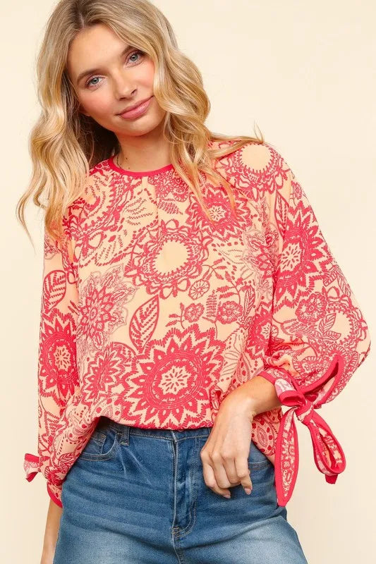 Floral round neck blouse with ribbon bow detail, long sleeves, and soft fabric from Trendsi.