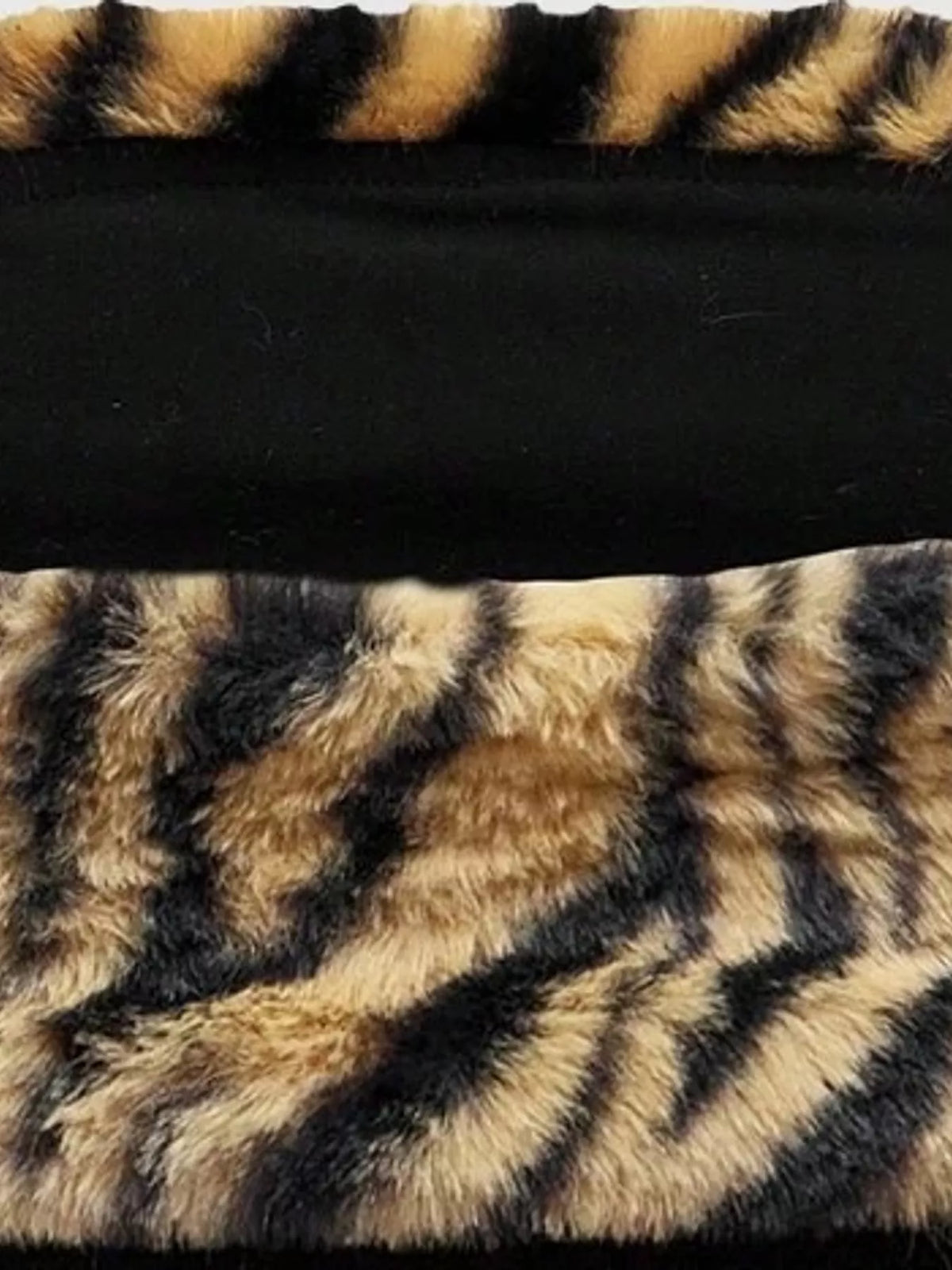 Zebra print faux fur trimmed tube top from Trendsi featuring a sleek, fitted design with fur accents and bold black and white pattern.