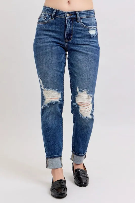 Plus size Judy Blue boyfriend jeans with mid-rise, distressed details, yoke pockets, and faux selvedge cuff, from Trendsi.