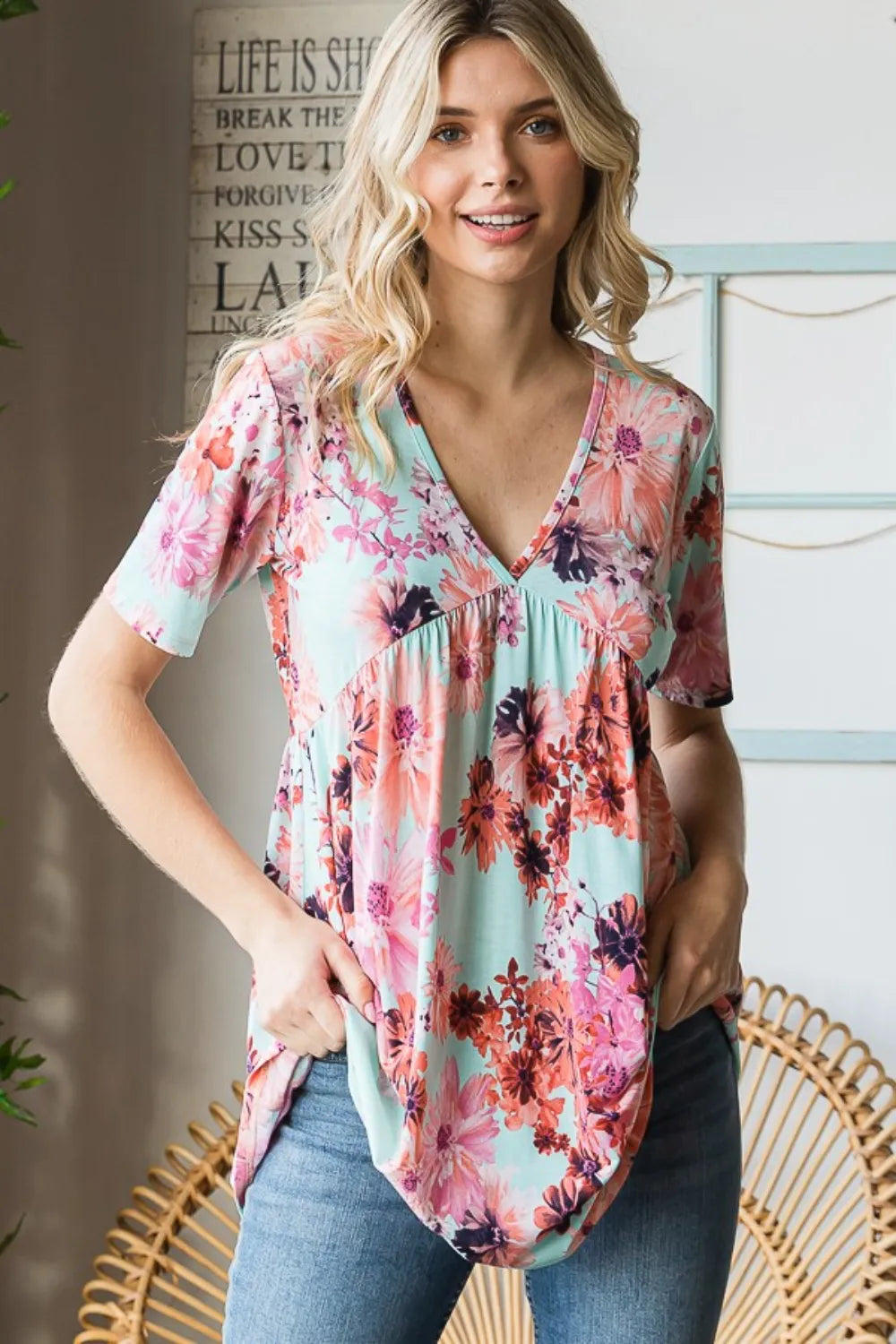 Heimish floral V-neck short sleeve babydoll blouse with a relaxed fit and feminine floral pattern, styled on a hanger.