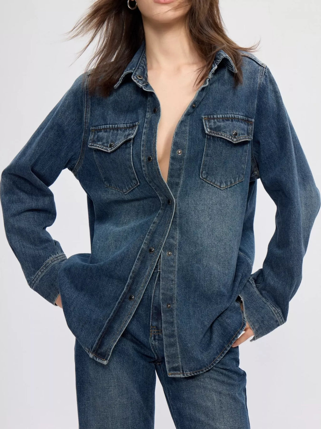 Long-sleeve denim shirt with snap-down front from Trendsi, shown in a classic blue wash on a model.