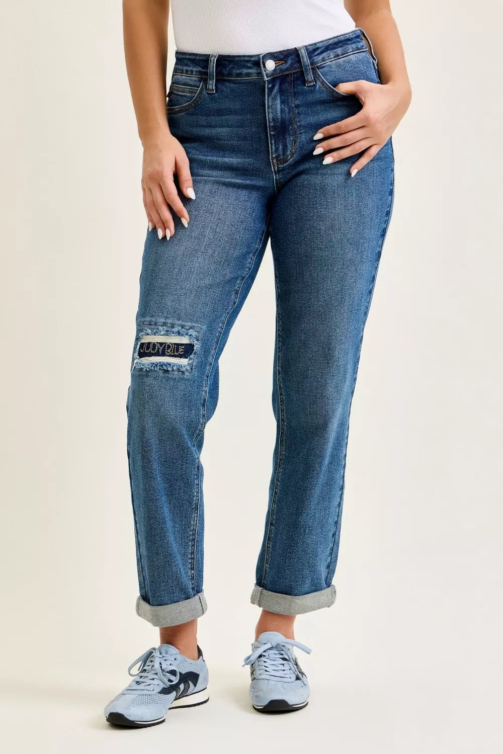 Light blue Judy Blue mid-rise boyfriend jeans with embroidered repair patches and distressed details, showcasing relaxed fit and stylish design.