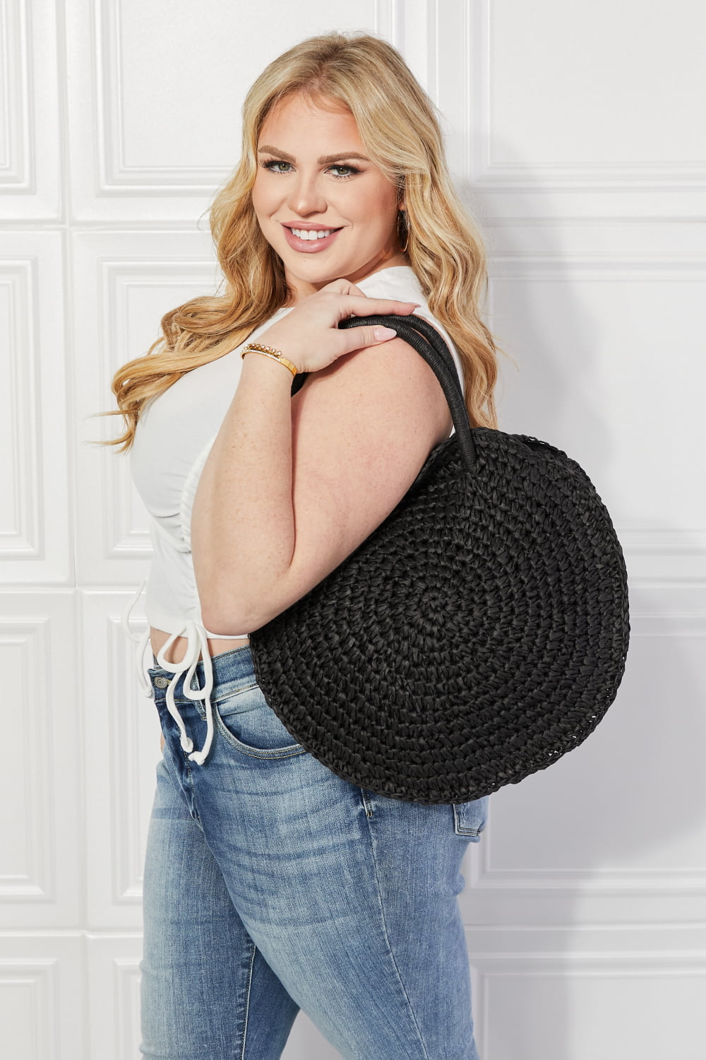 Justin Taylor Beach Date straw rattan handbag in black with rounded shape and woven design, perfect for casual summer outings.