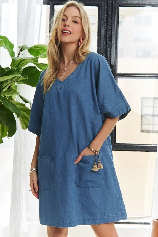 Trendsi ADORA V-neck half sleeve mini denim dress displayed on a model, featuring a fitted silhouette and classic blue denim fabric.