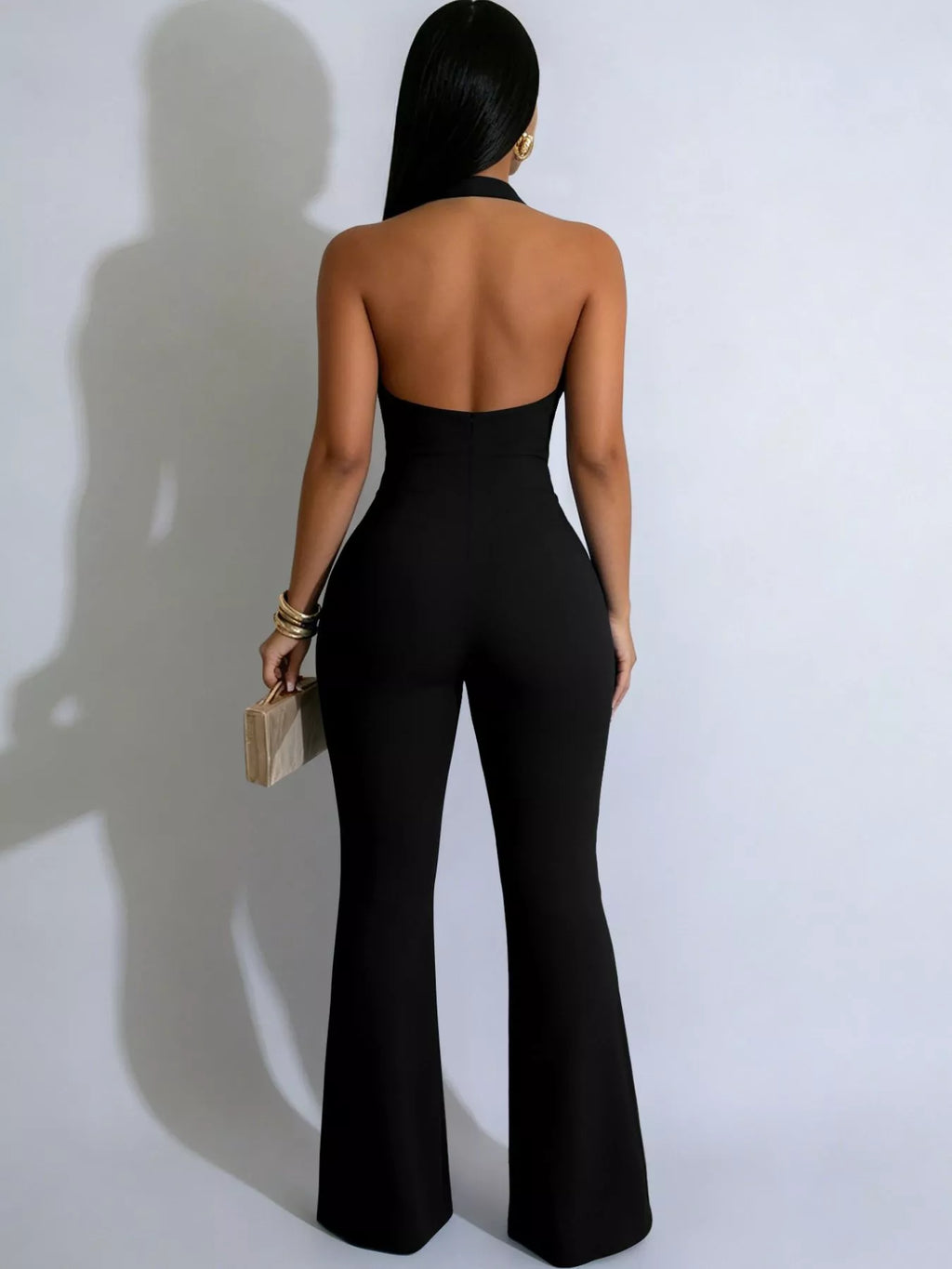 Halter neck cut-out flare jumpsuit with button details, styled with trendy design and fitted silhouette, by Trendsi.