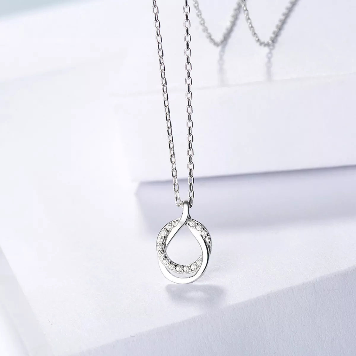 Sterling silver zircon pendant necklace with a delicate chain, featuring a sparkling zircon stone in a stylish design.