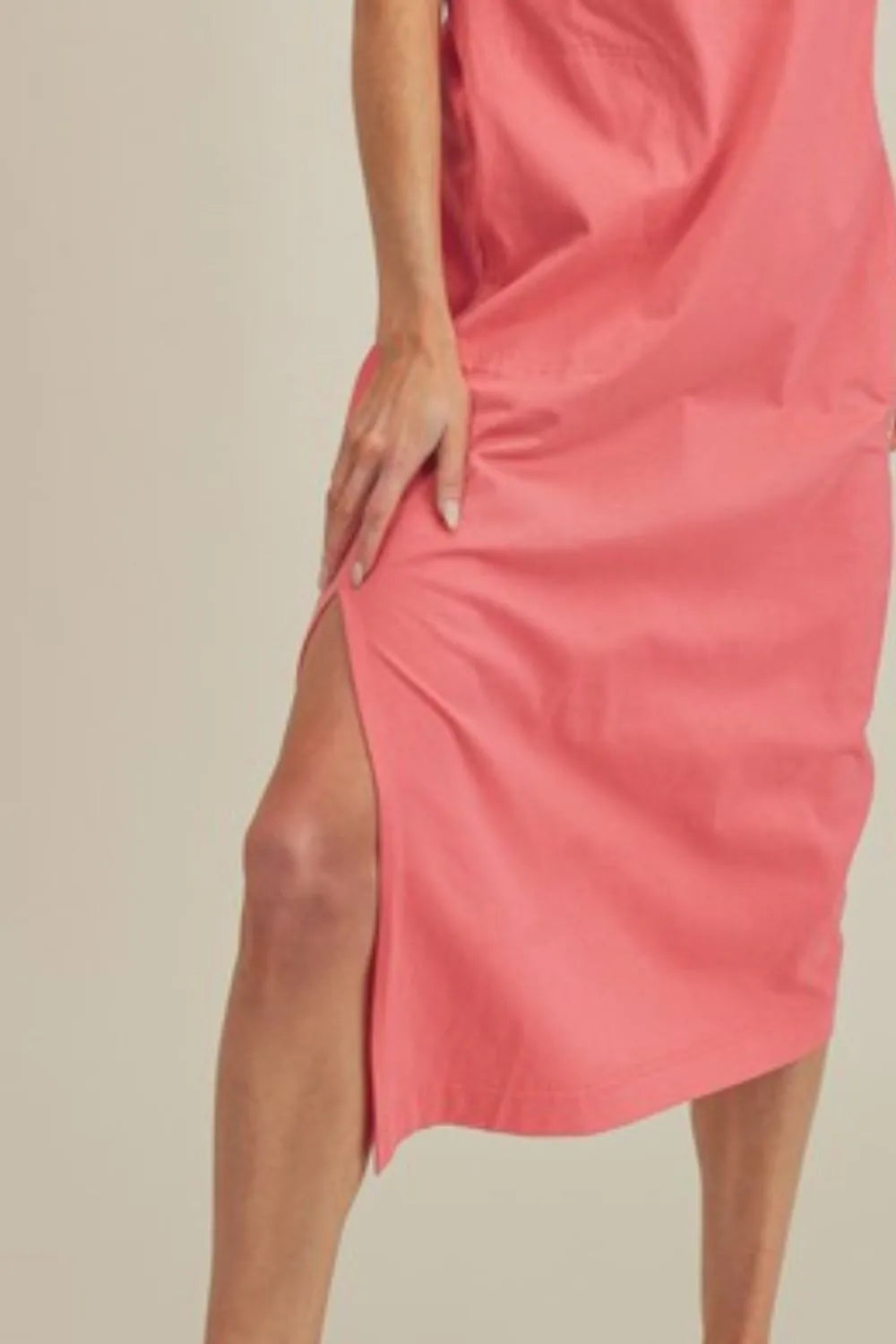 Coral Aemi + Co sleeveless midi dress with side slit and round neck, stylish and comfortable for casual or dressy occasions.
