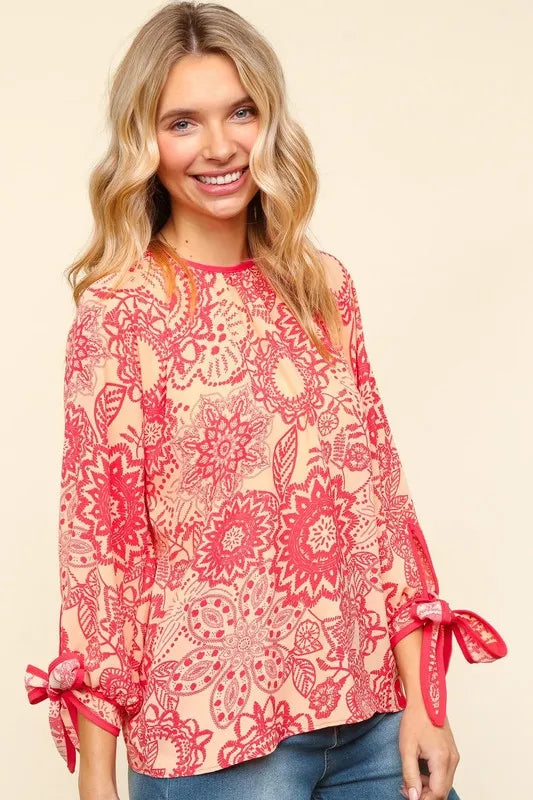 Trendsi floral round neck blouse with ribbon bow detail, featuring a feminine design and soft fabric.