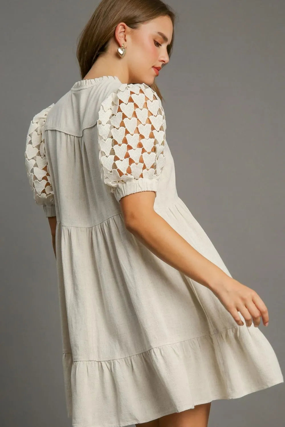 Plus size Umgee dress with ruffled hem, heart lace sleeves, and tie neck, featuring a stylish and feminine design.