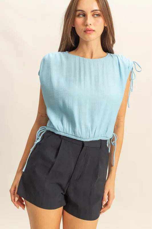 Trendy sleeveless blouse by HYFVE featuring a round neck, bubble hem, and side tie detail in a stylish, casual design.