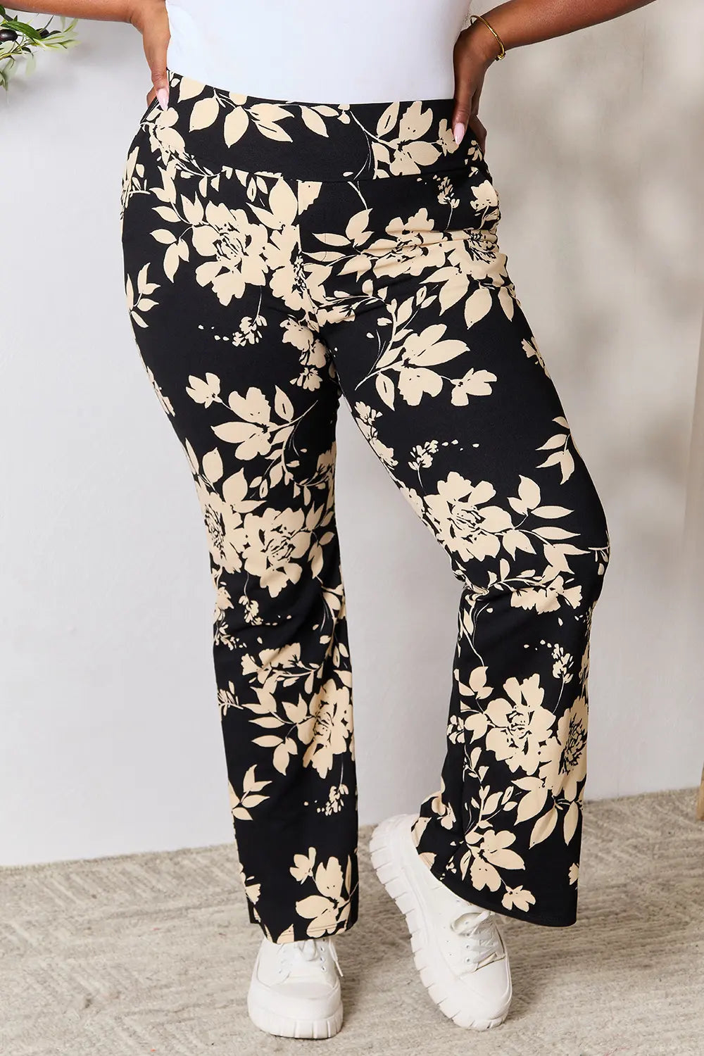 Heimish high waist floral flare pants in plus size, featuring a vibrant floral pattern and wide-leg design, modeled on a person.
