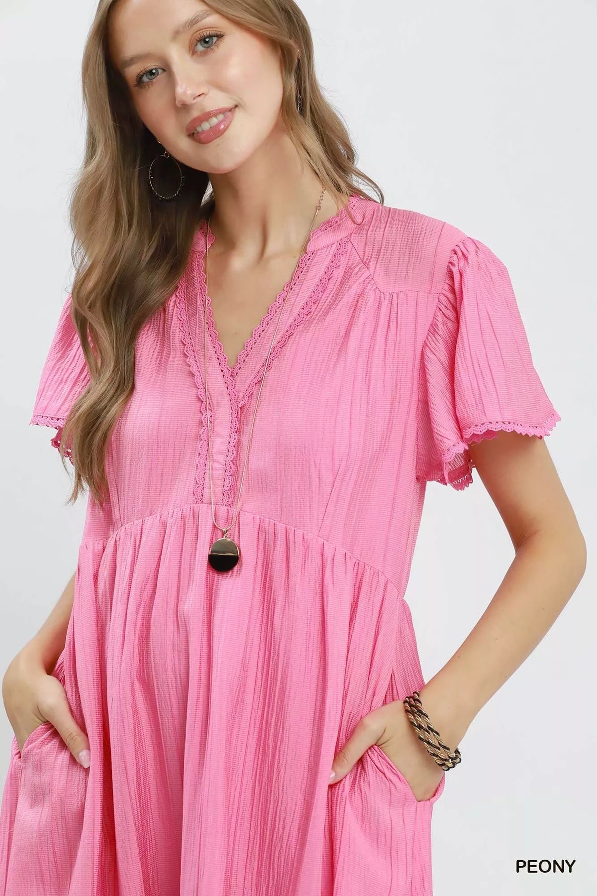 Textured tiered midi dress by Umgee with side pockets, featuring a flowy silhouette and stylish design in natural fabric.