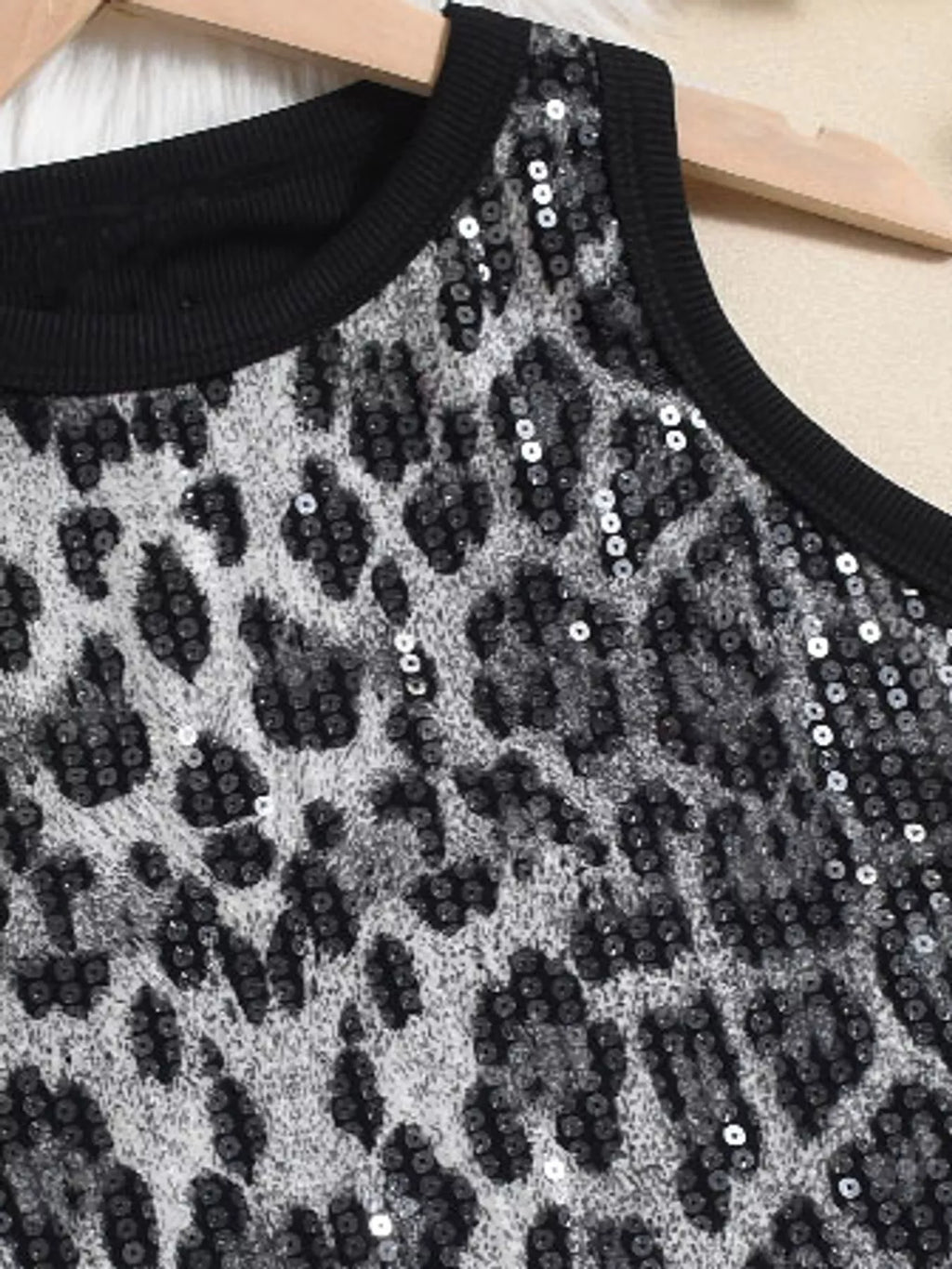 Sequin round neck tank top by Trendsi featuring shimmering sequins and a classic sleeveless design on a white background.