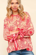 Floral round neck blouse with ribbon bow detail by Trendsi, featuring a stylish and feminine design.