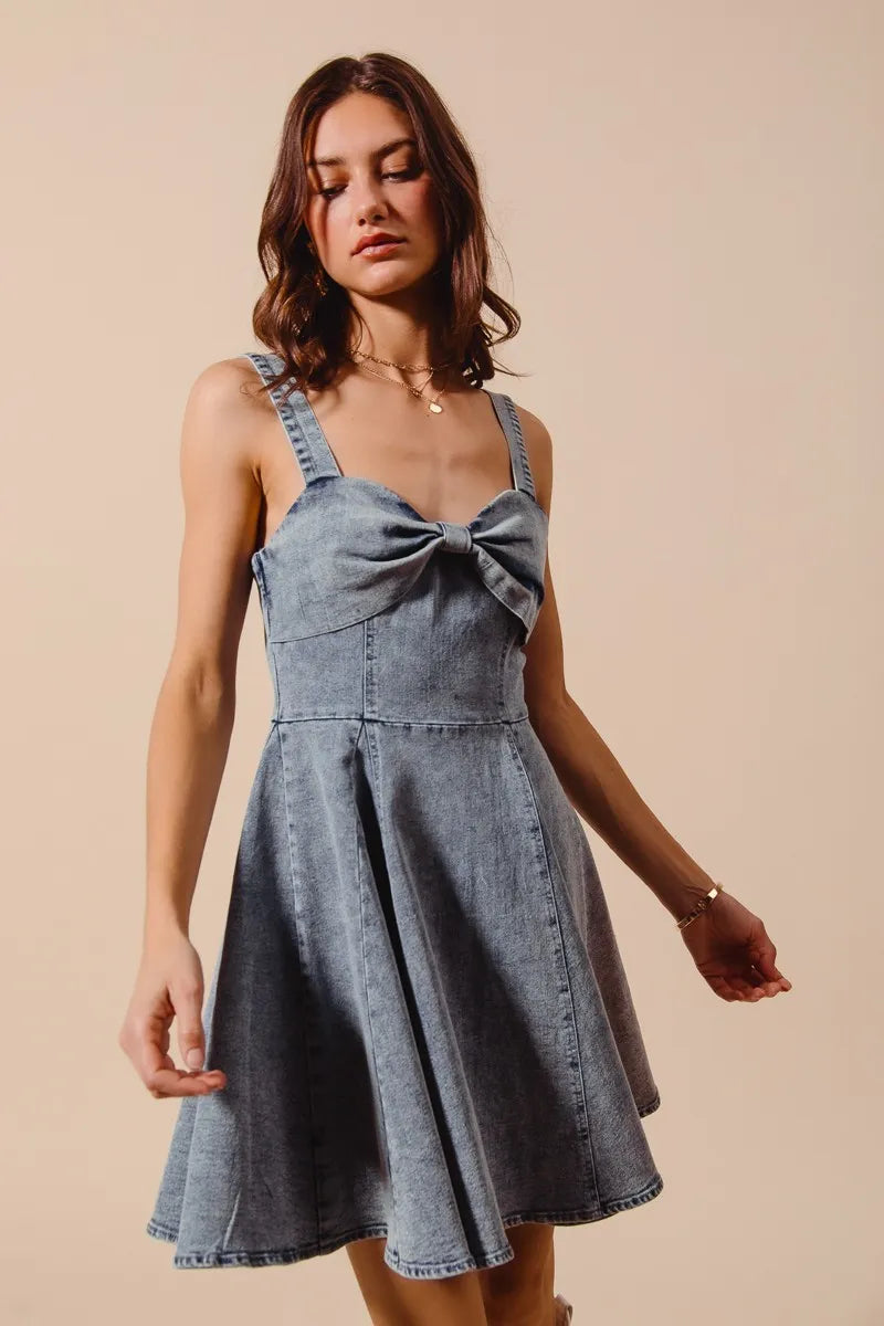 Mineral washed bow ribbon denim flare dress by Trendsi featuring a fitted bodice and flowing skirt, perfect for casual or stylish occasions.