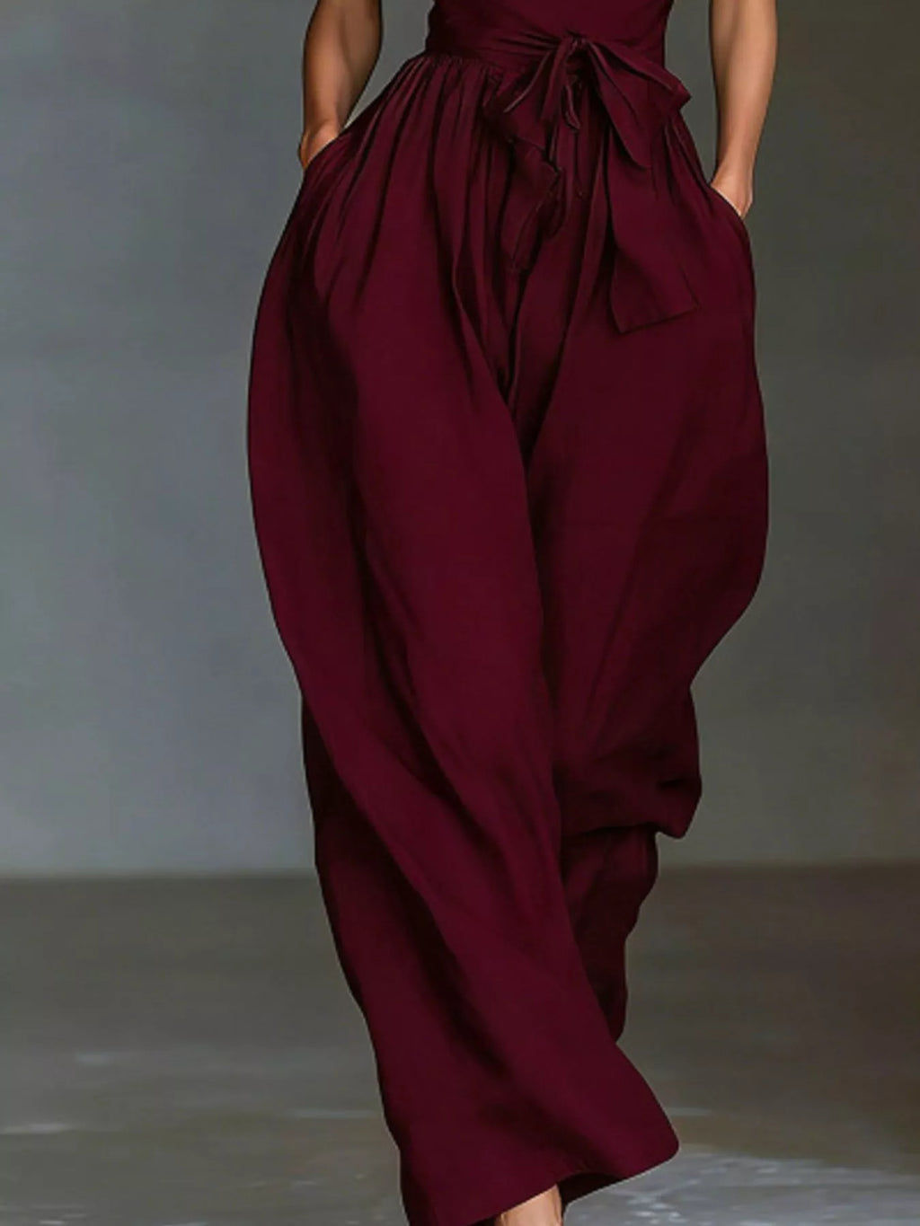 Halter neck wide-leg jumpsuit with waist-tie detail, black fabric, and stylish design from Trendsi.