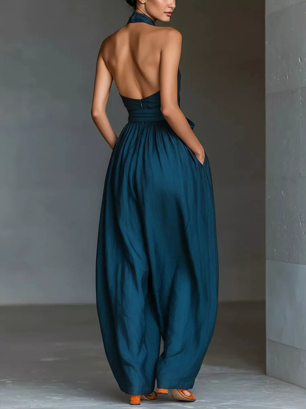 Halter neck wide-leg jumpsuit with waist-tie detail, trendy fashion piece from Trendsi, shown in black fabric with flowing silhouette.
