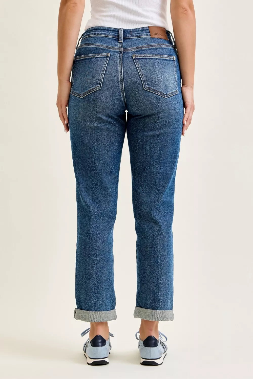 Light blue Judy Blue mid-rise boyfriend jeans with embroidered repair patches and distressed details, featuring a relaxed fit.