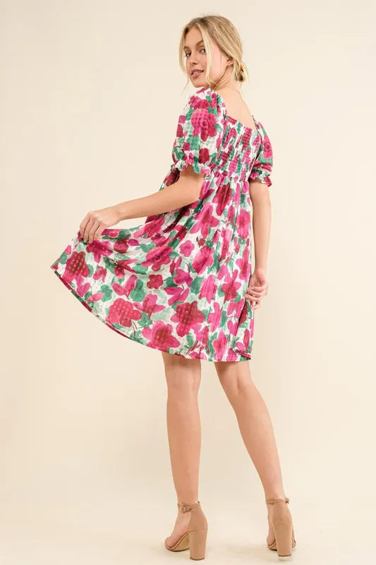 Floral smocked ruffle short sleeve mini dress by Trendsi, featuring a feminine design with floral patterns and ruffle details.