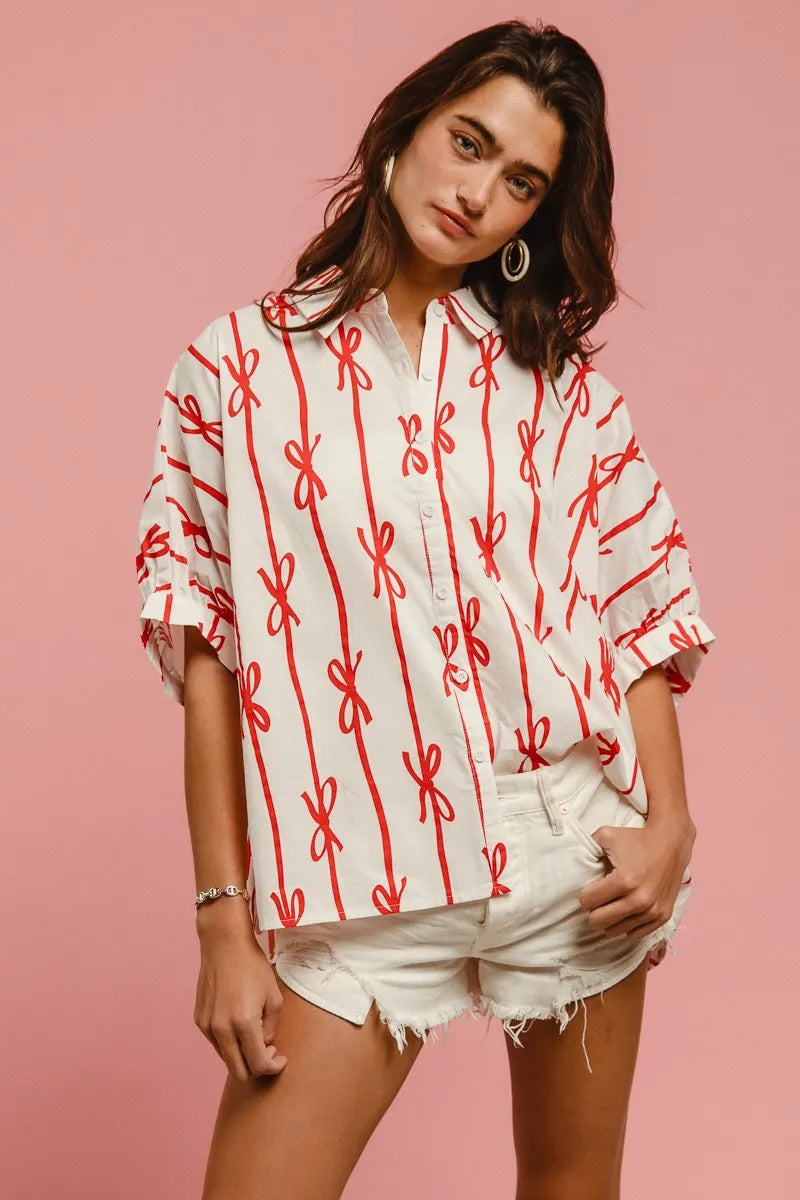 Woven printed button-down shirt with BiBi Bow Ribbon details from Trendsi, featuring a colorful pattern and tailored fit.