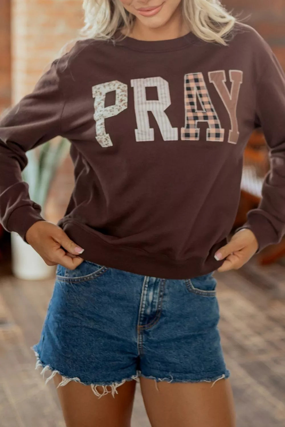Dark brown crewneck sweatshirt with plaid PRAY graphic, view 2