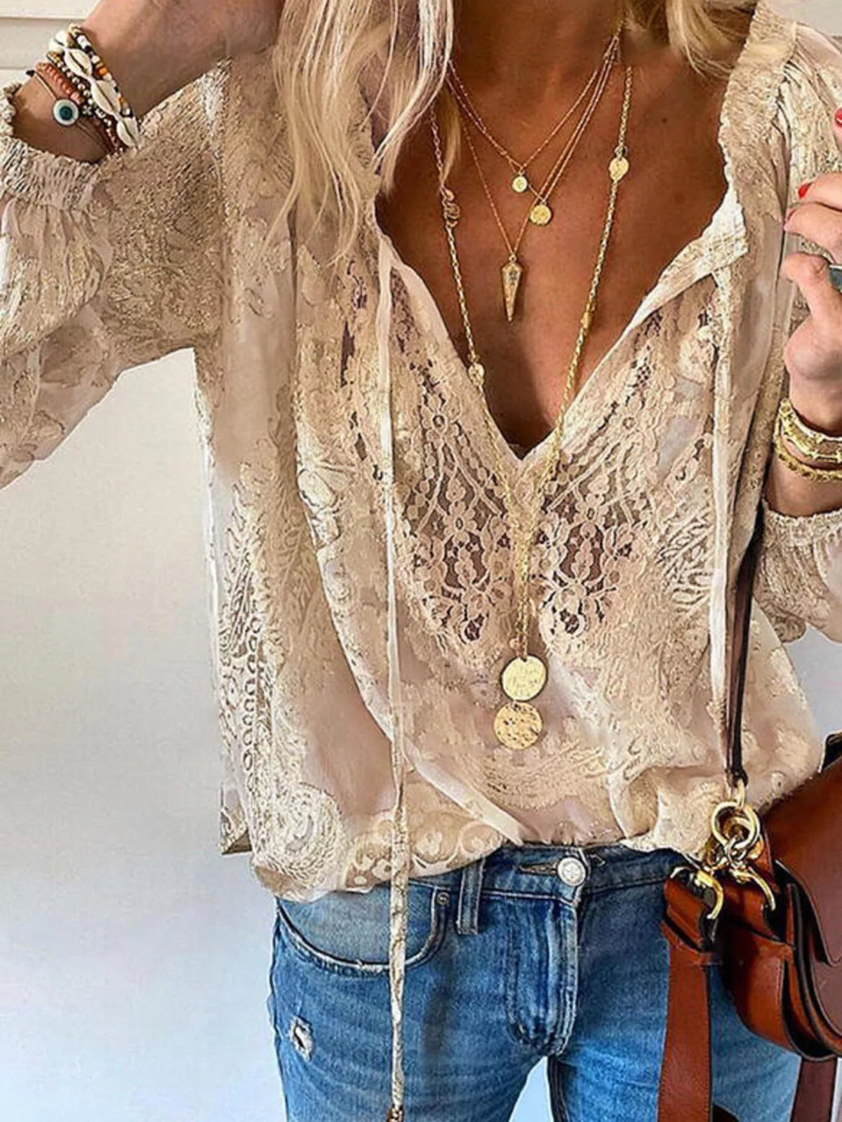 Lace tie-neck blouse by Trendsi featuring delicate lace details and a stylish tie at the neckline, displayed on a white background.