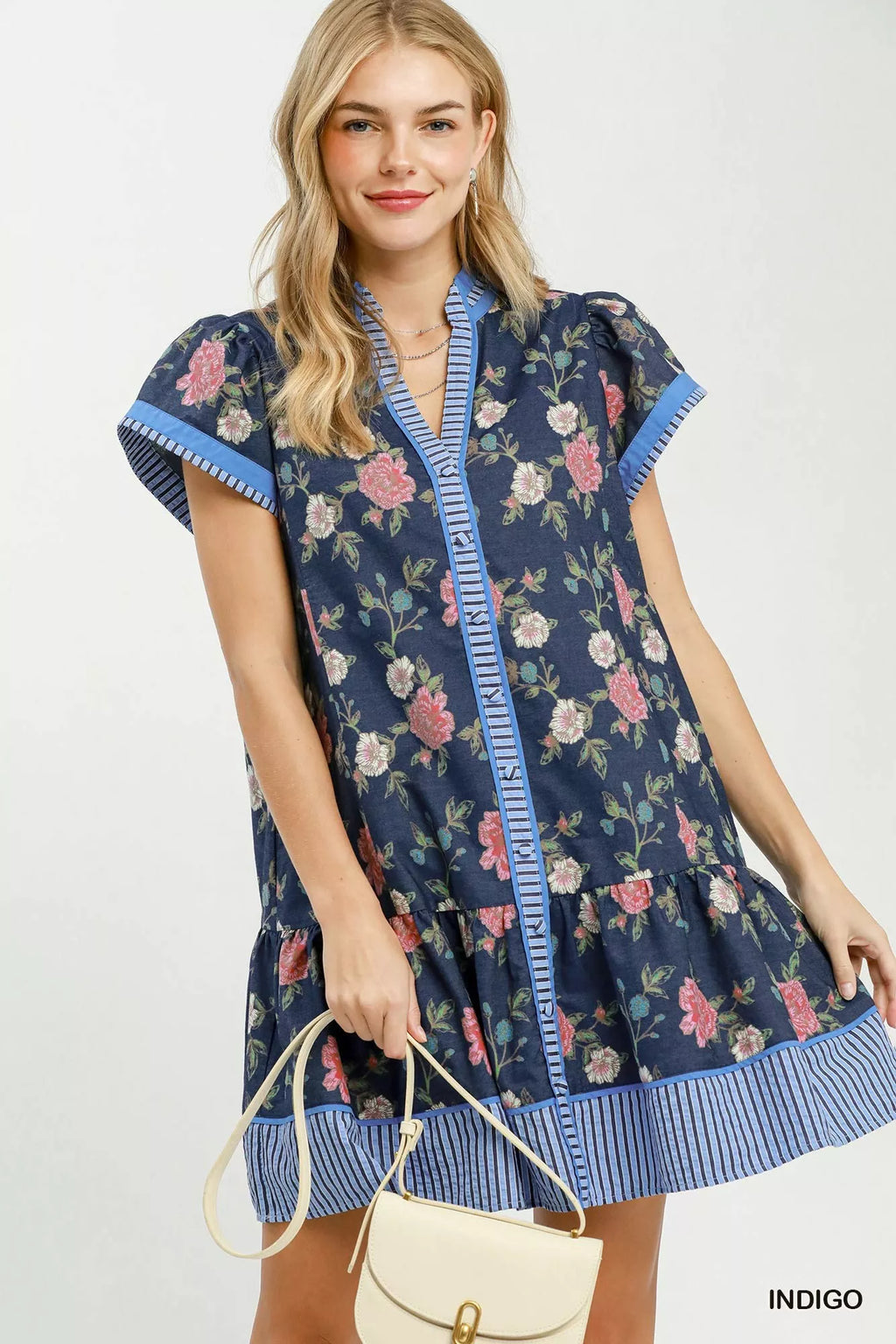 Umgee floral mini dress with contrast trim and ruffle hem, featuring a feminine design and vibrant floral pattern.