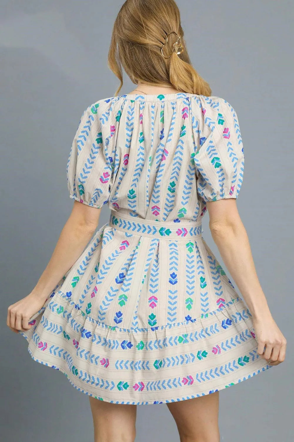 Umgee printed tie waist puff sleeve mini dress by Trendsi, featuring a colorful floral pattern and short puff sleeves.