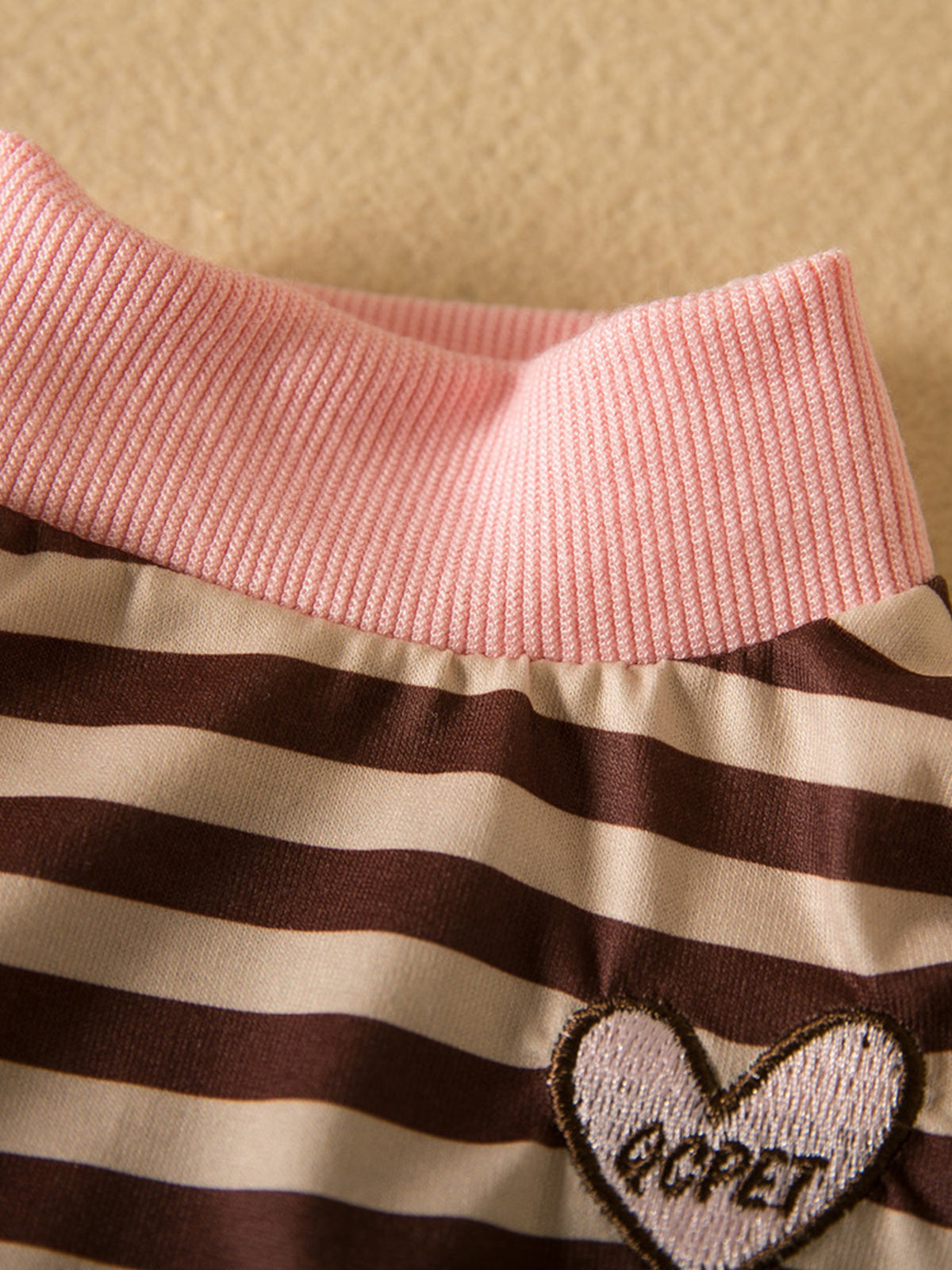 Striped heart patch on pet top from Trendsi, featuring colorful vertical stripes and a cute heart design.