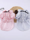 Striped ruffle pet top with bow from Trendsi, featuring colorful stripes and a cute bow detail on a small dog.