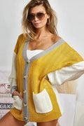 Color block sweater cardigan with button closure from Trendsi, featuring a stylish, cozy knit design and vibrant color segments.