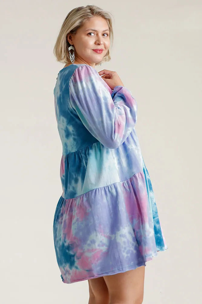 Plus size Umgee tie dye baby doll dress with round neck, long sleeves, tiered skirt, and relaxed fit, styled for a casual look.