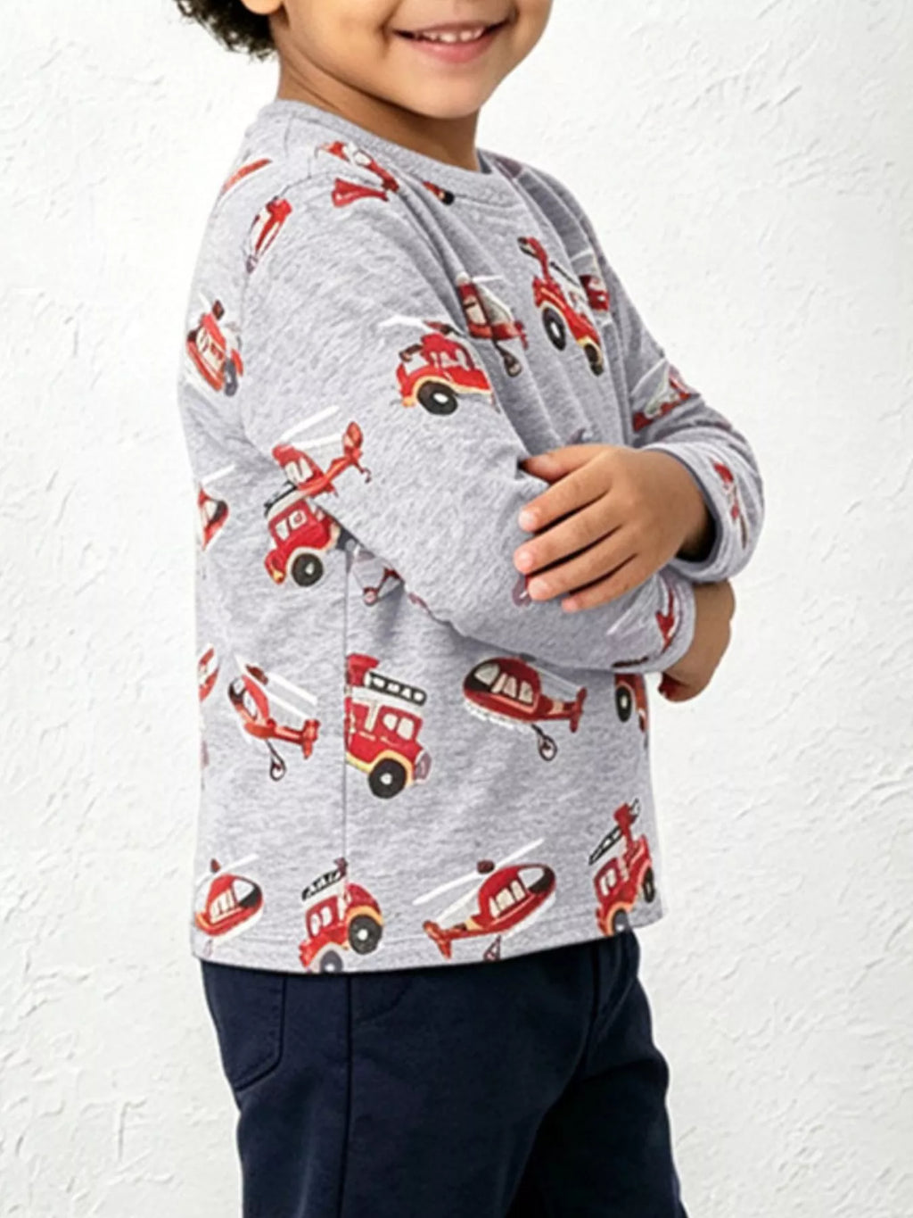 Children's fire truck and helicopter print long sleeve T-shirt by Trendsi featuring colorful vehicle graphics on a cream crew neck shirt.