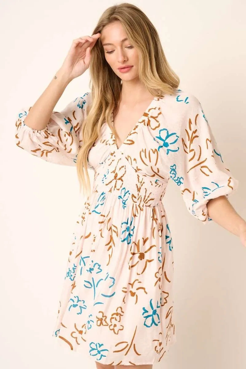 Trendsi Mittoshop flower print mini dress with a mocked waist, sleeveless design, and vibrant floral pattern on lightweight fabric.