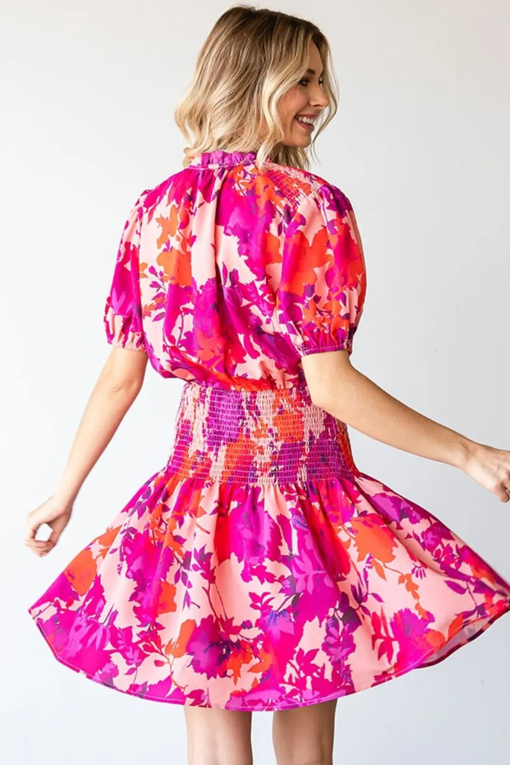 First Love Floral short sleeve smocked mini dress by Trendsi, featuring a vibrant floral pattern and a comfortable, fitted style.