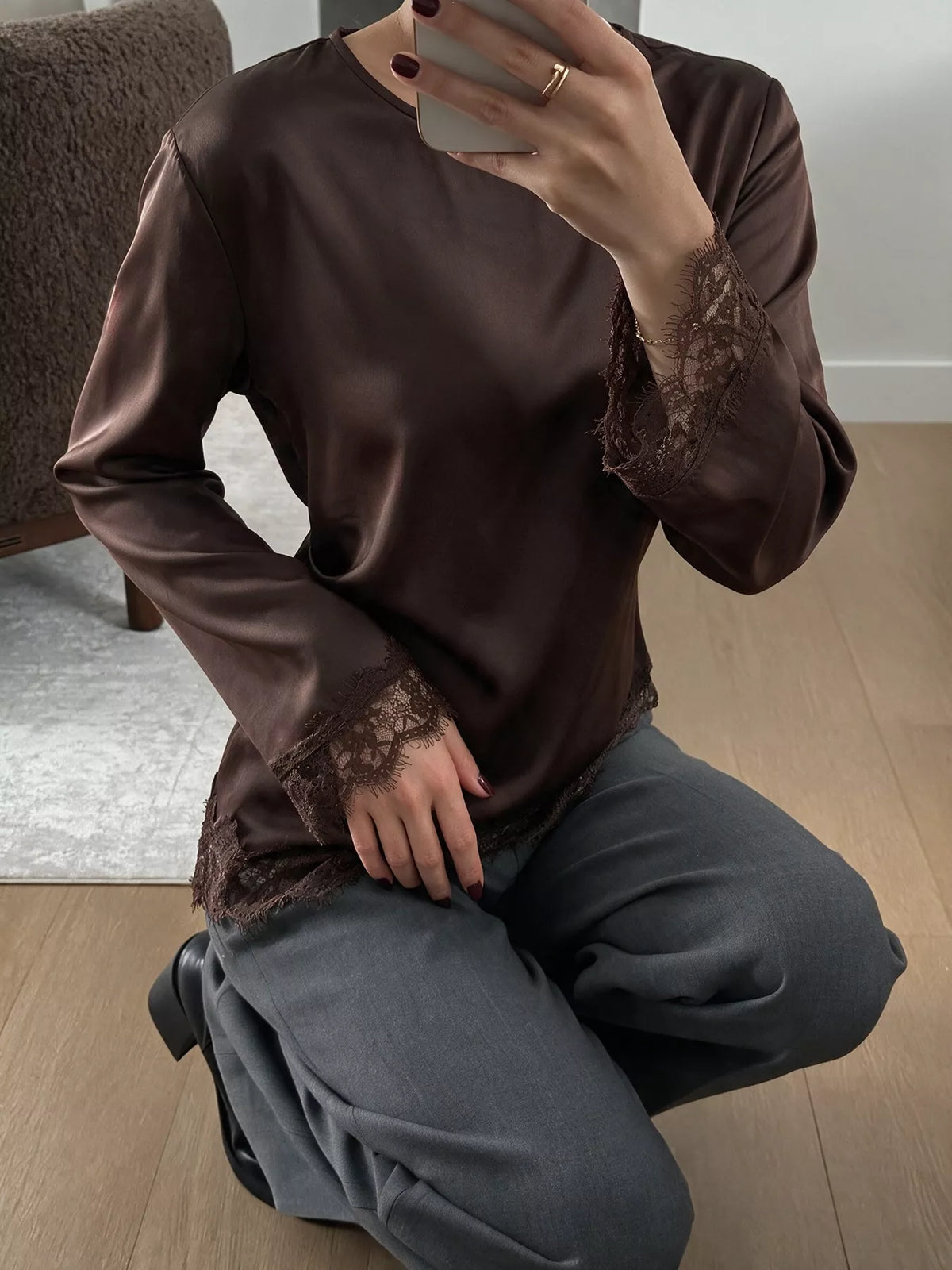 Long sleeve satin blouse with lace trim, featuring elegant design and smooth fabric, ideal for stylish, sophisticated wear.