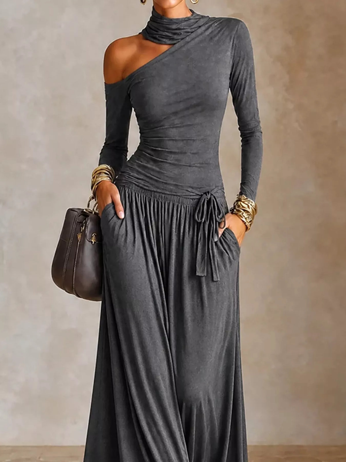 Asymmetric cutout long sleeve maxi dress by Trendsi, featuring a stylish design with cutouts and a flowing silhouette.