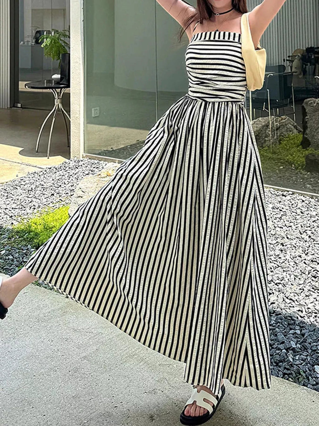 Striped spaghetti strap A-line maxi dress by Trendsi, featuring a flowing silhouette and bold stripe pattern.