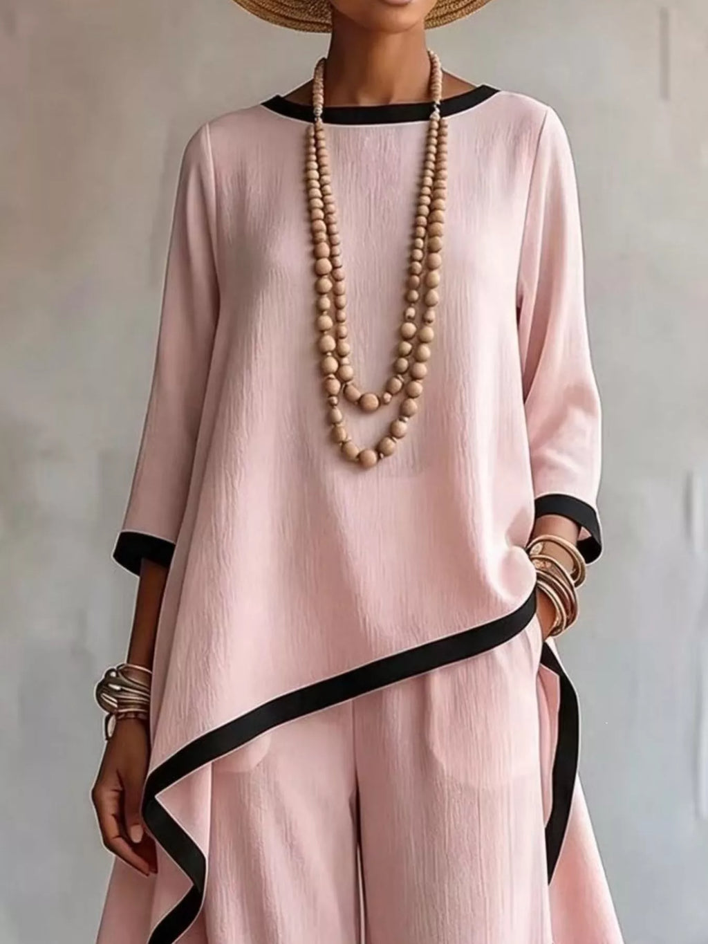 Plus size high-low top and pants set by Trendsi with contrast trim, casual style, and comfortable fit, shown in natural fabric detail.