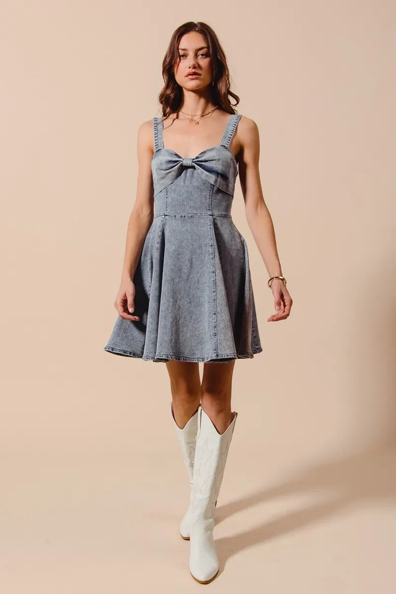 Mineral washed bow ribbon denim flare dress by Trendsi featuring a fitted bodice and flowing skirt, perfect for casual or stylish occasions.