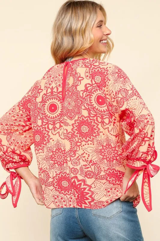 Floral round neck blouse with ribbon bow detail from Trendsi, featuring a feminine design and lightweight fabric.