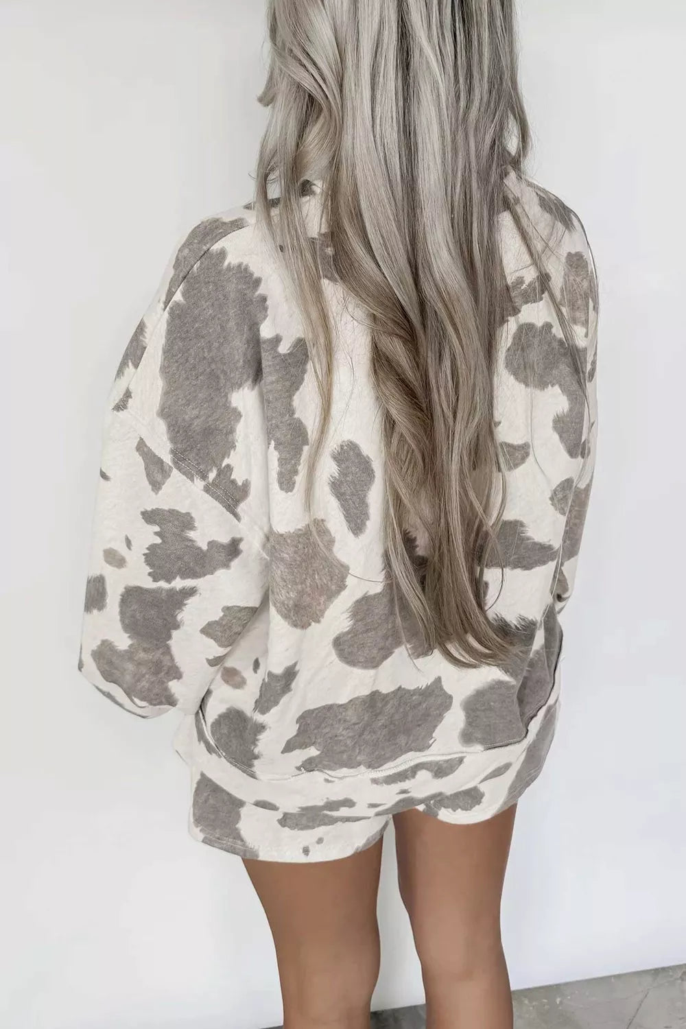 Cow print top and drawstring shorts set from Trendsi, featuring a playful black and white cow pattern with comfortable fabric.