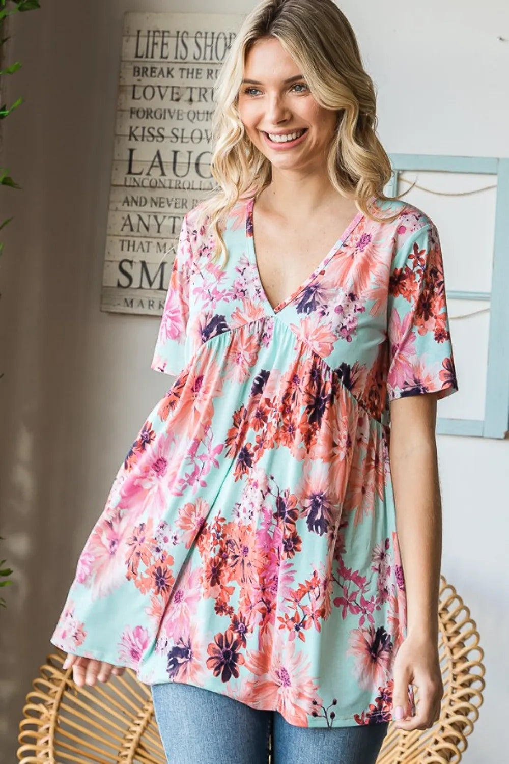 Heimish full size floral V-neck short sleeve babydoll blouse with a feminine design, featuring a relaxed fit and floral print.