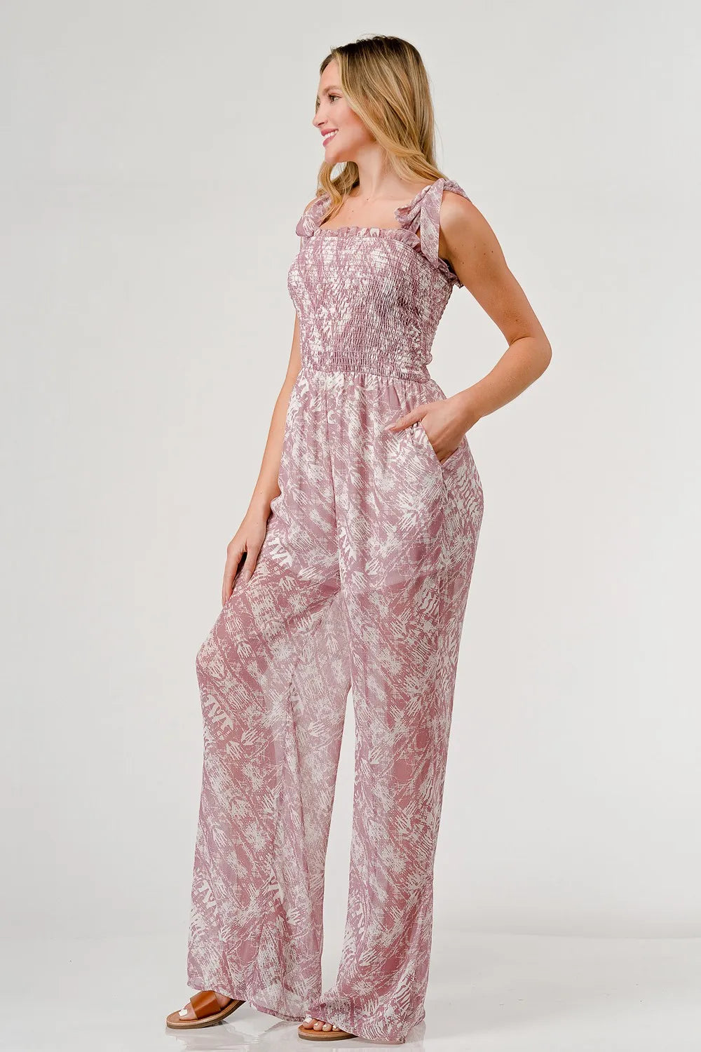 Printed tie shoulder wide leg jumpsuit by Trendsi, featuring a stylish design with a comfortable fit and wide-leg silhouette.